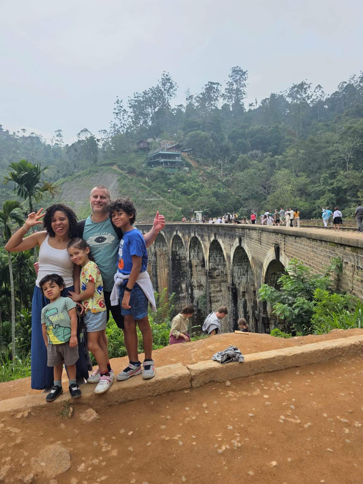 International tourists walking along the railway tracks of the Demodara Nine Arch Bridge